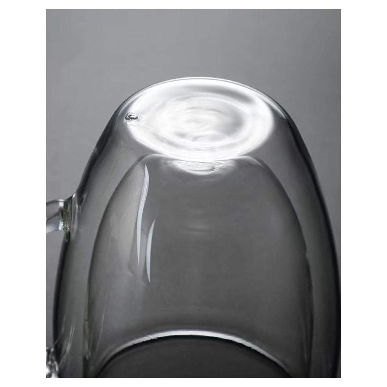Close-up of a clear glass teapot on a gray background