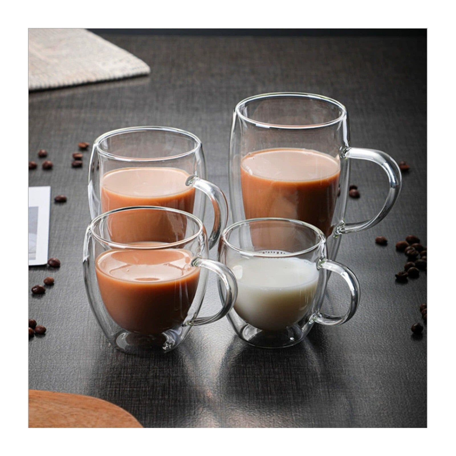 Four glass mugs with handles, each containing different types of hot beverages, on a dark surface with coffee beans around.