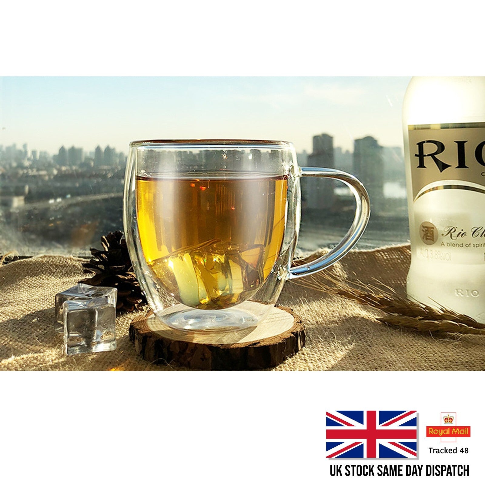 Clear mug with tea and a bottle of Ricard on a wooden coaster with a cityscape background
